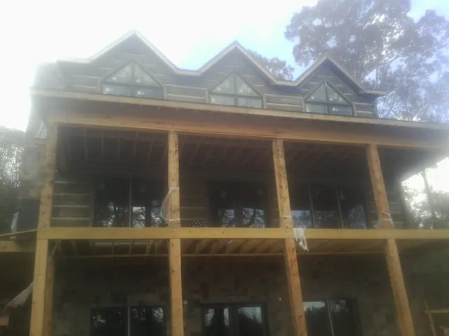 Dormers and porch framing on a large log home under construction — Roof Coating work by our crew in Brandon
